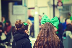 st. patrick's day: two girls with a green bow and green four-leaf clover