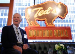 The Summit: Ted Turner in front of his Ted's Montana Grill sign