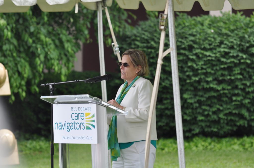 Bluegrass Care Navigators: a woman in a white suit at a podium speaking