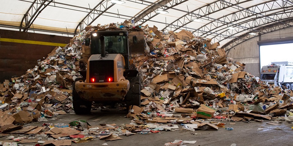 Paper Recycling: a big construction vehicle driving over paper