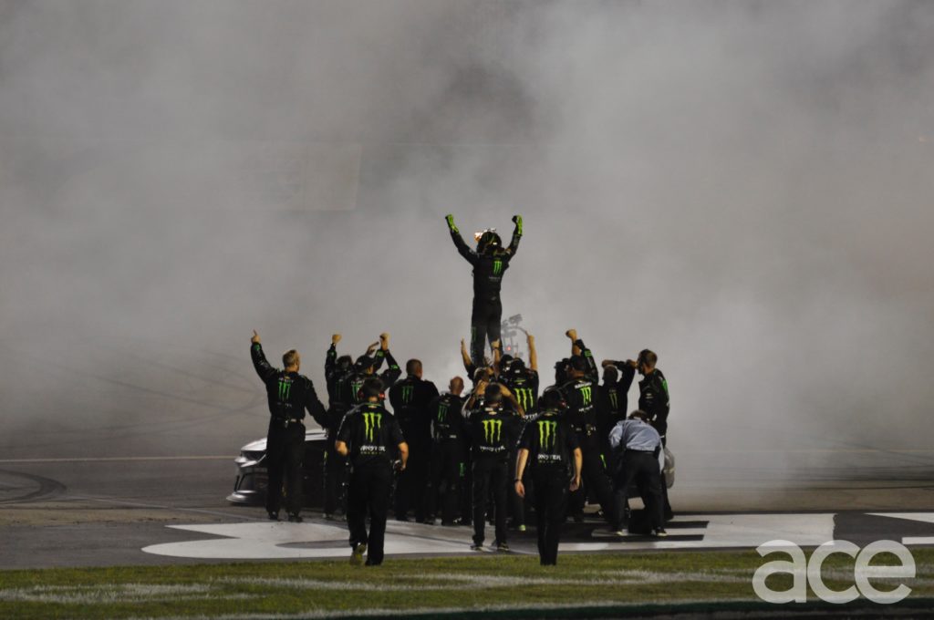 Kurt Busch standing on his car as the Monster Energy team celebrating the win.