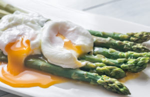Steamed asparagus with poached eggs on the plate