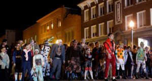 Halloween: people dressed as zombies walking down a street