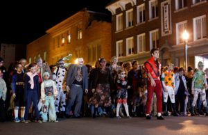 Halloween: people dressed as zombies walking down a street