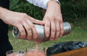 A bartender creating a pink drink