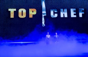 man and woman standing in front of a top chef sign with lots of smoke