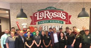 LaRosa's: large group of people standing in front of a brick wall with a logo