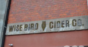 sign on a brick building that says wise bird cider co.