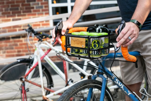 a bike with a basket and west sixth brewing beer in the basket