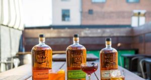 Bulleit Distilling: bourbon bottles and glass sitting on a picnic table