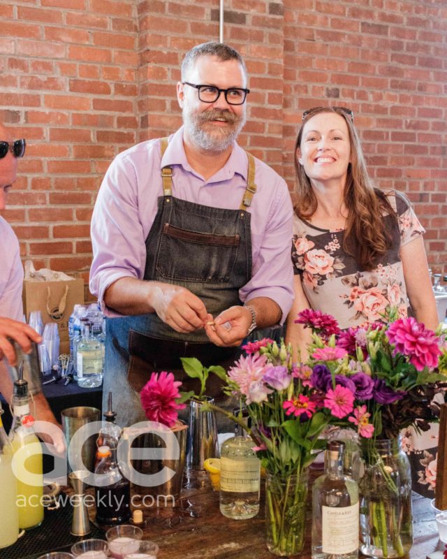 Castle & Key: a man in a purple top with an apron smiling off camera and a woman next to him smiling at the camera