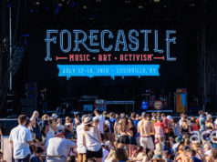 A stage with people in front and a sign that says Forecastle