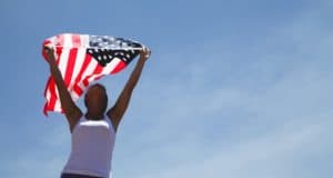 a woman holding an American Flag in the air