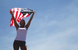 a woman holding an American Flag in the air